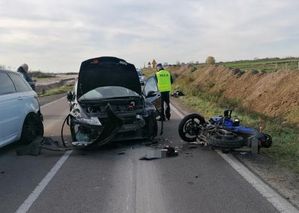 miejsce wypadku dwa samochody osobowe jeden rozbity na drodze leży motocykl