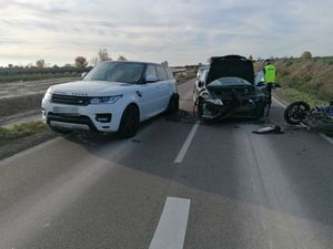 miejsce wypadku dwa samochody osobowe jeden rozbity na drodze leży motocykl