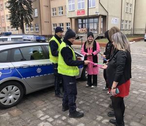 policjanci rozdają elementy odblaskowe