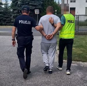 policjanci prowadzą zatrzymanego