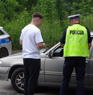 policjant prowadzący kontrolę obok chłopak biorący udział w akcji