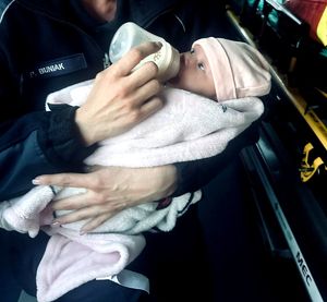 policjantka karmi niemowlę mlekiem z butelki