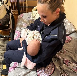 policjantka trzyma niemowlę na rękach