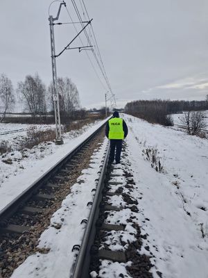 policjant patroluje teren linii kolejowej
