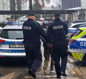 policjanci prowadzą osobę zarrzymaną