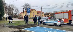 miejsce zdarzenia parking przed budynkiem radiowóz policyjny i straż pożarna, policjanci