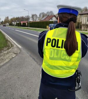 umundurowana policjantka trzyma w ręku urządzenie do pomiaru prędkości