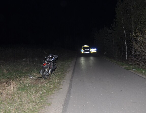 miejsce wypadku stojący na poboczu motocykl w oddali policyjny radiowóz