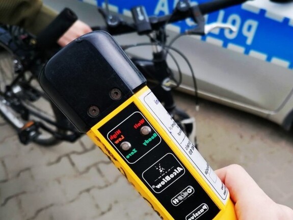 urządzenie do badania trzeźwości w tle policyjny radiowóz i rower