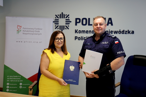 komendant wojewódzki policji wspólnie z panią dyrektor pfron trzymają podpisane porozumienie.jpg