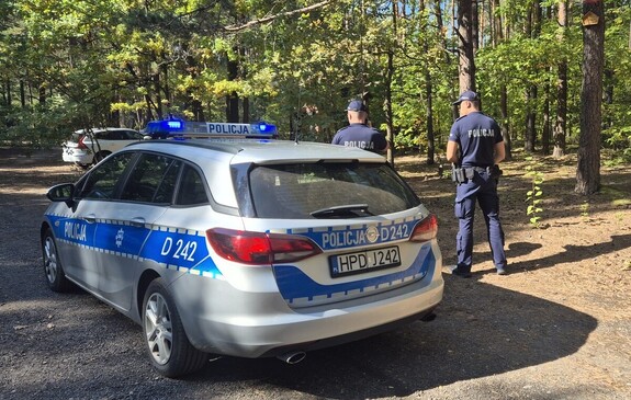 policjanci przy radiowozie zabezpieczają miejsce zdarzenia